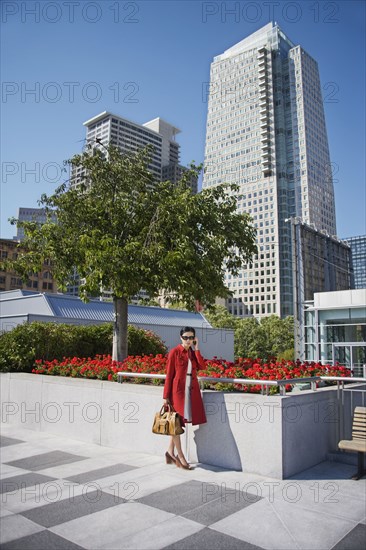 Asian businesswoman talking on cell phone outdoors