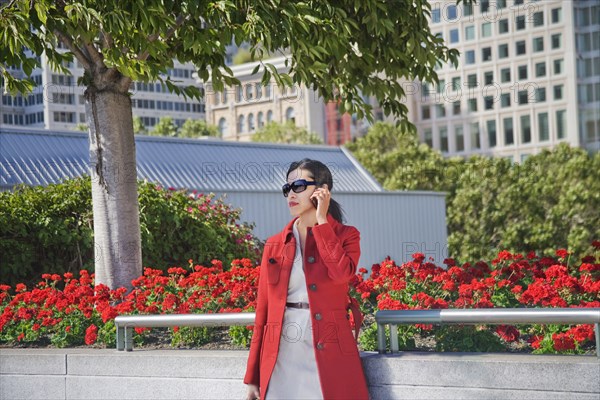 Asian businesswoman talking on cell phone outdoors