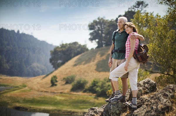 Couple standing on rocks admiring river
