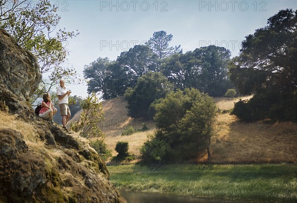 Couple standing on rocks admiring river