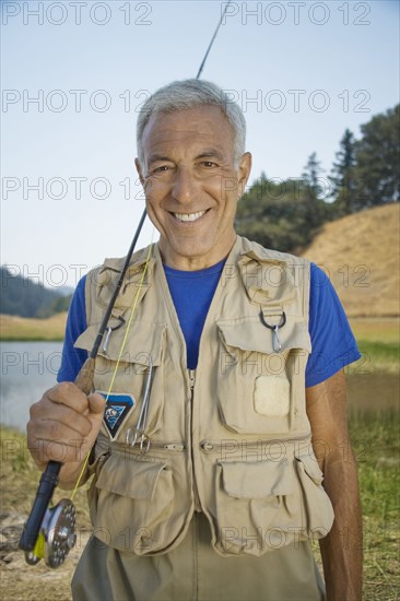 Portrait of smiling Caucasian man holding fishing rod