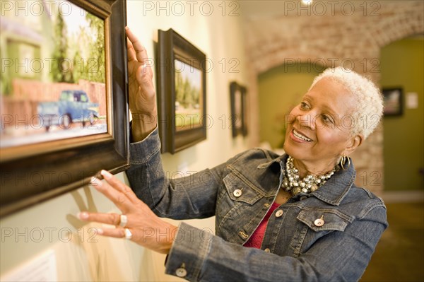 Black woman admiring painting in gallery