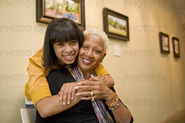 Grandmother and granddaughter hugging in gallery