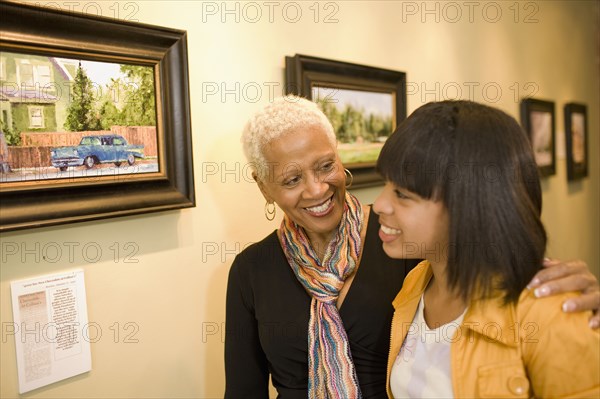 Grandmother and granddaughter hugging in gallery