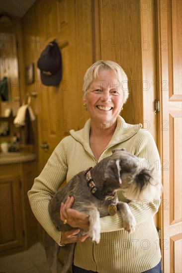 Smiling Caucasian woman  holding dog