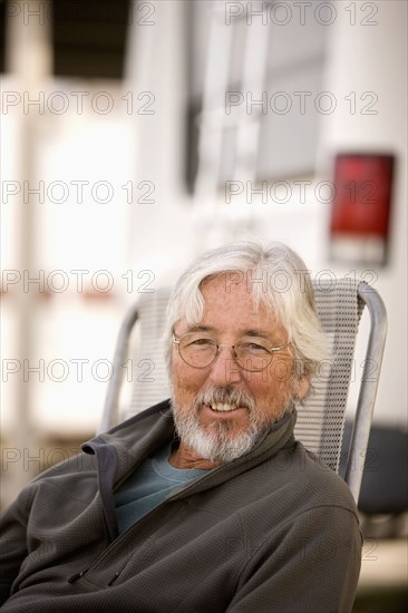 Senior Caucasian man sitting outside motor home