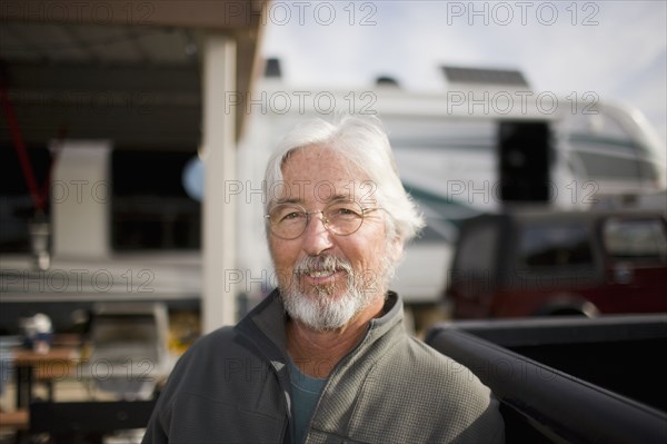 Senior Caucasian man sitting outside motor home