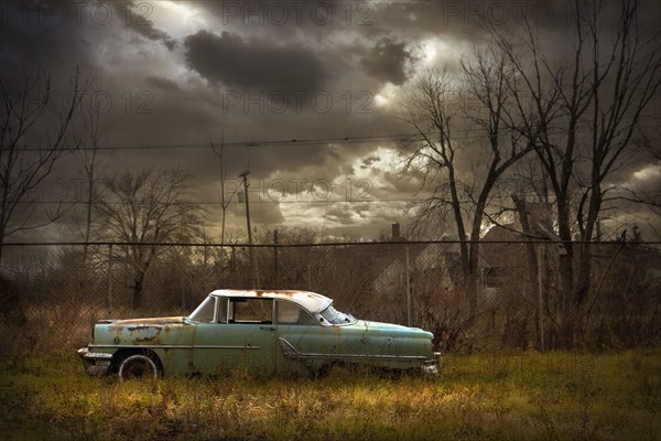 Rusted car in dilapidated urban field