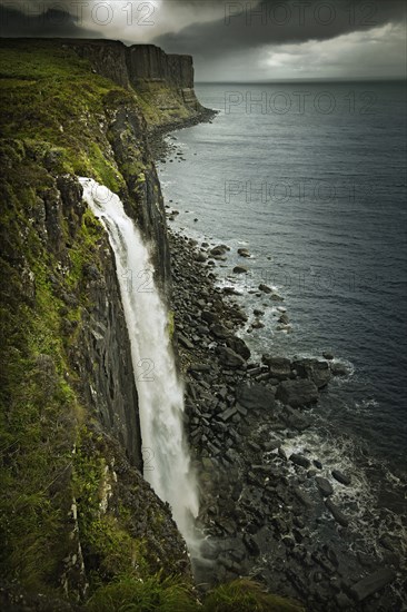 Waterfall over rural coastline