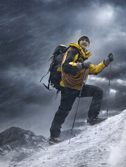 Caucasian man climbing snowy mountain