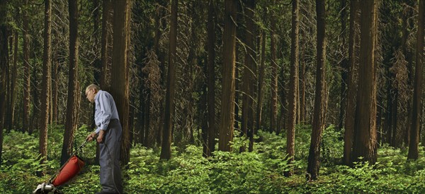 Caucasian man vacuuming forest floor