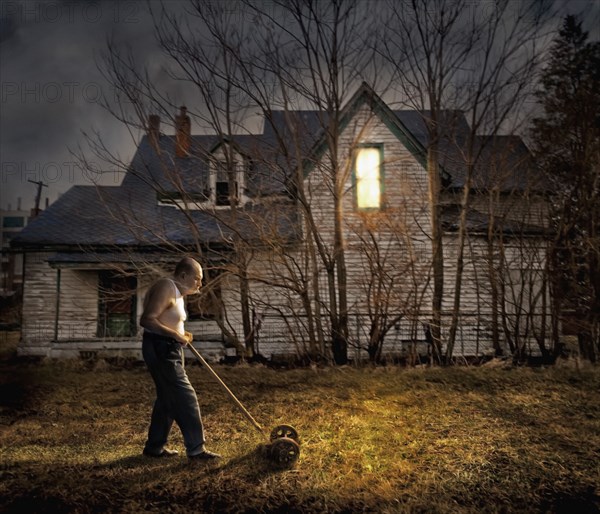 Caucasian man mowing lawn outside home