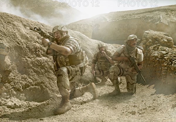 Soldiers advancing in dry rural landscape