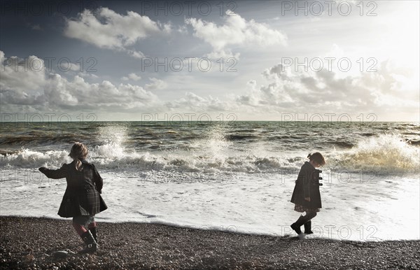 Children playing on rocky beach