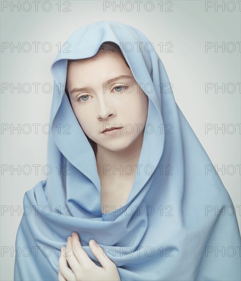 Caucasian girl wrapped in blanket