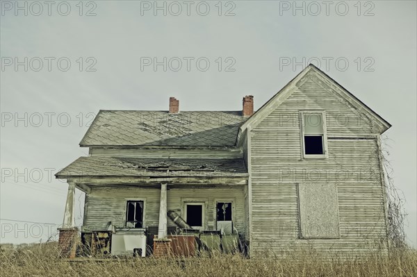 Dilapidated house in dry field