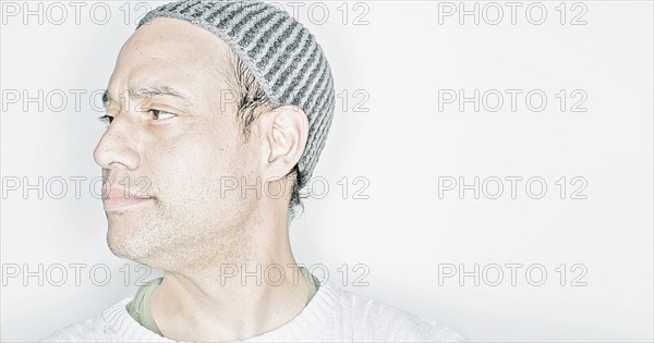 Mixed race man wearing cap