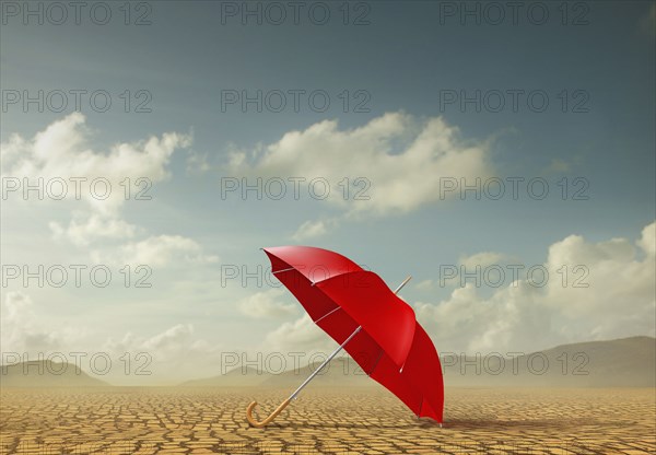 Red umbrella in desert landscape