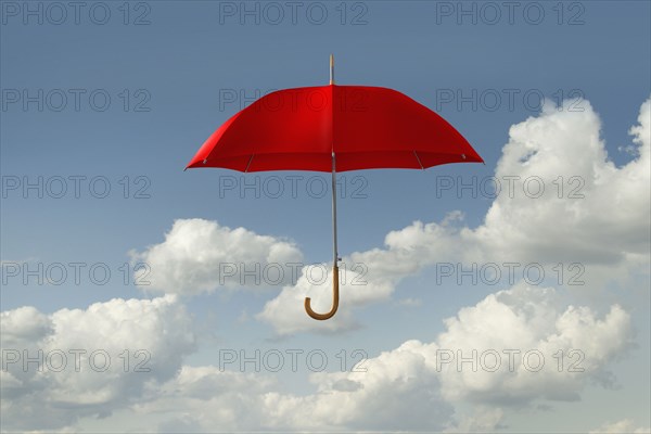 Red umbrella floating in clouds