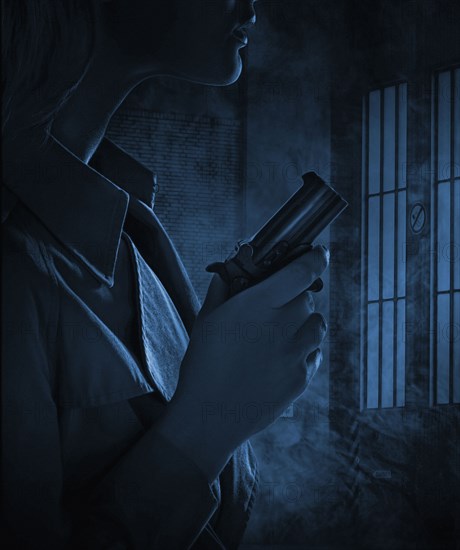 Silhouette of woman holding gun in dark room