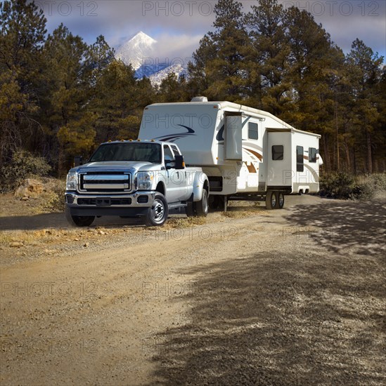 Truck pulling RV trailer on dirt road