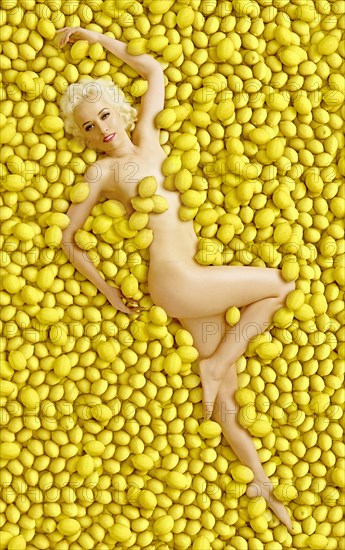 Caucasian woman laying in pile of lemons