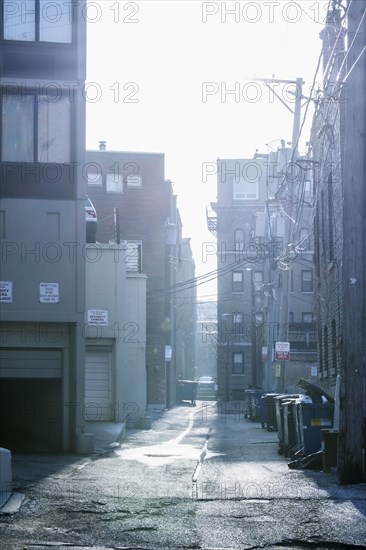 Garbage cans in urban alleyway