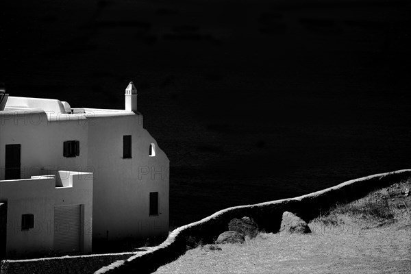 Dirt path and building overlooking coastline