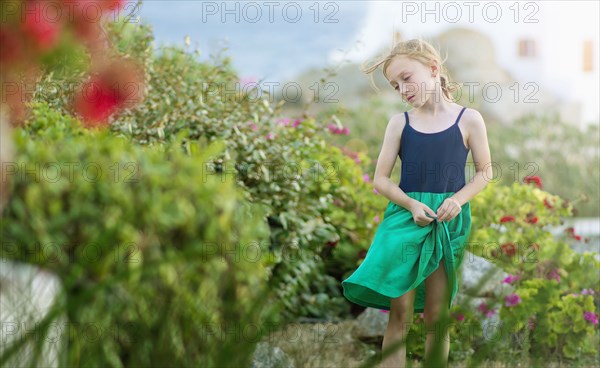 Caucasian girl walking in field of flowers