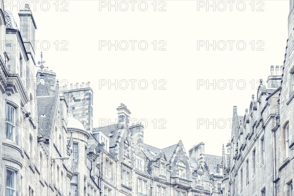 Low angle view of townhouse roofs and chimneys