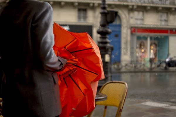 Close up of woman opening umbrella on rainy city street