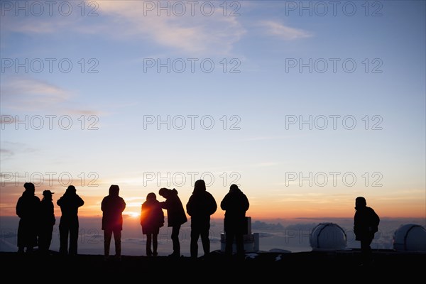 Silhouette of tourists admiring view from mountaintop