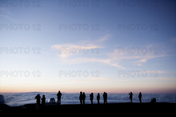 Silhouette of tourists admiring view from mountaintop