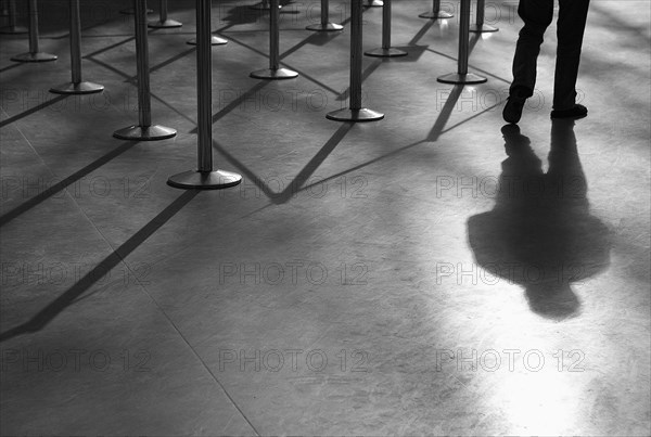 Shadow of man and roped-off barriers