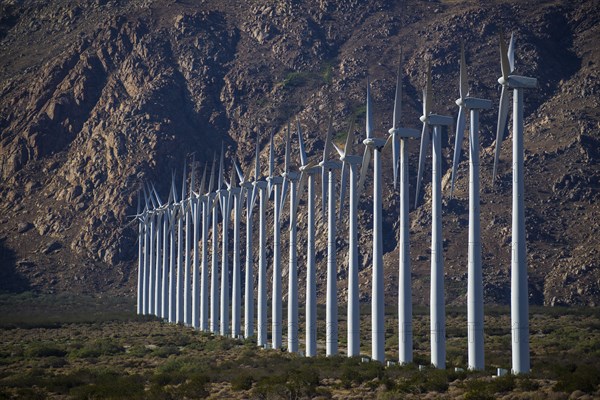 Row of wind turbines in rocky remote landscape