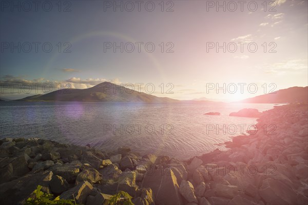 Sunrise over hills and lake in rocky remote landscape