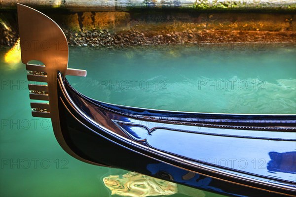 Close up of ornate gondola decoration on canal