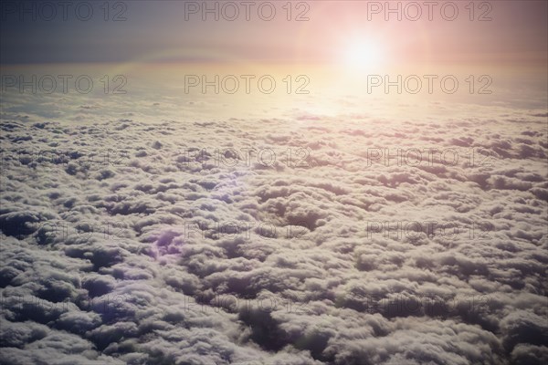 Sun shining in sky above clouds