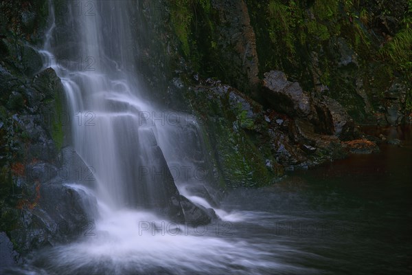 Waterfall flowing over rocky cliff