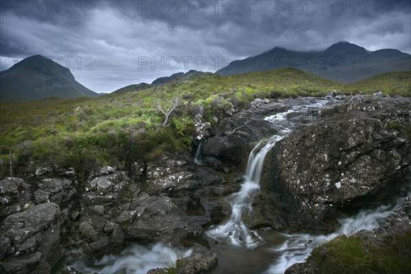 Waterfall over rocks in rural landscape