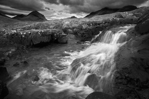 Waterfall over rocks in rural landscape