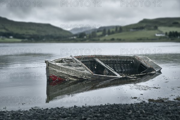 Dilapidated boat in rural lake