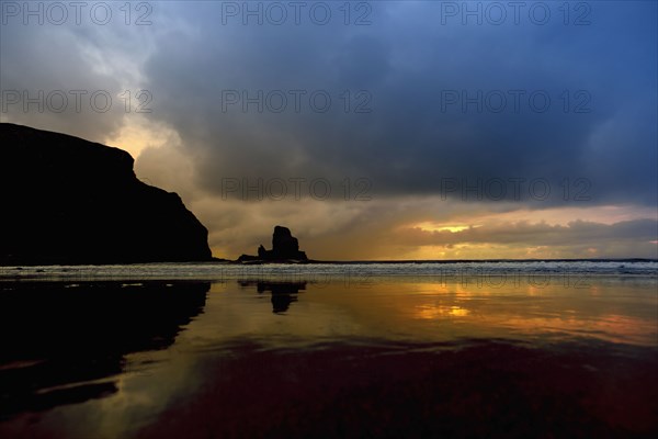 Storm clouds over waves on beach