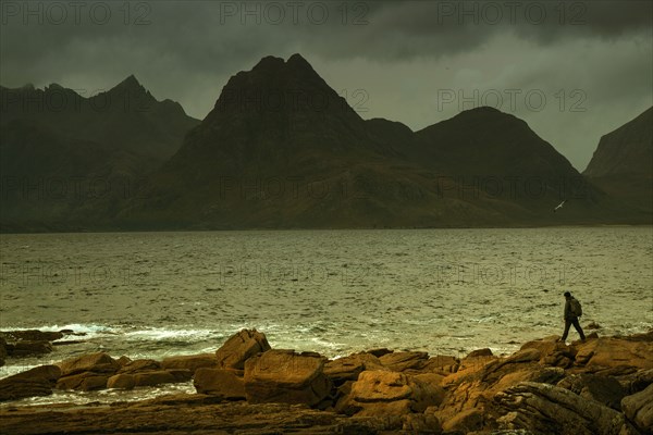 Man walking on rocky beach