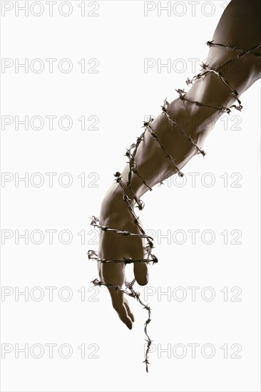 Arm and hand wrapped in barbed wire