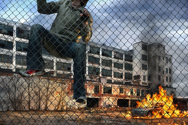 Man scaling wall in gritty urban neighborhood