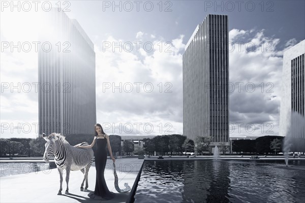 Woman and zebra in urban park