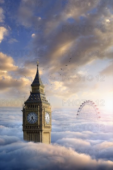 Birds flying around clock tower near ferris wheel above clouds