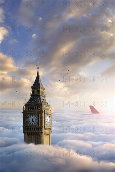 Birds flying around clock tower near airplane rudder above clouds