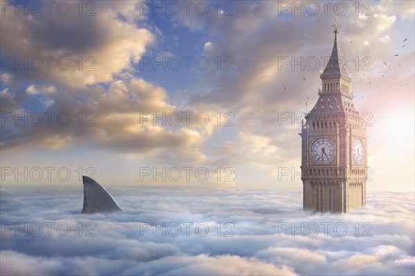 Birds flying around clock tower near shark fin above clouds